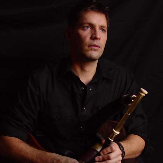 Chrsitopher-Layer man with wind instrument in front of black background