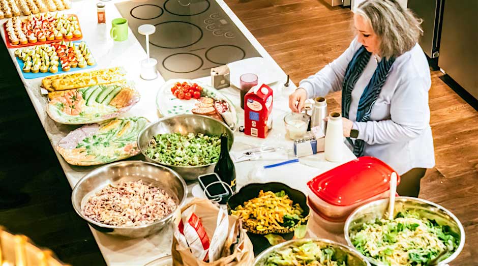 lady chef preparing loads of yummy food paltters on large kitchen counter